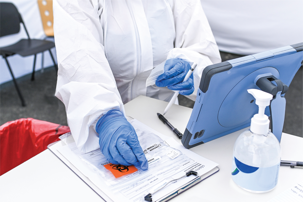 StemExpress Medical Assistant placing a label onto a patient's test sample during a COVID-19 drive through testing event early May 2020